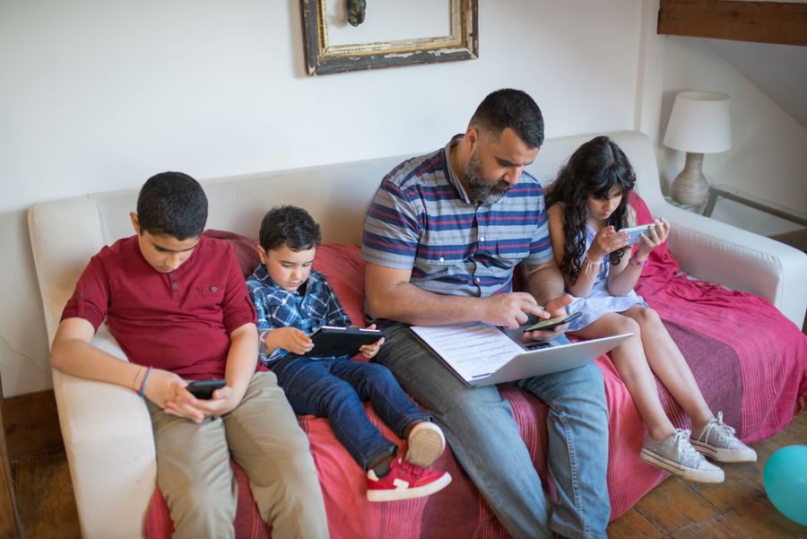 Familia en casa conectada a internet con varios dispositivos